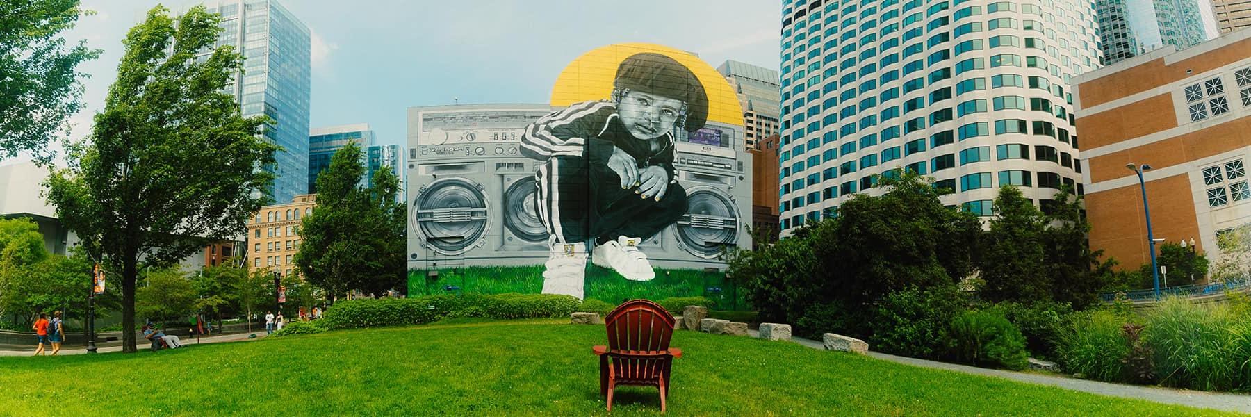 ProBlak mural of person in front of boombox on building on Boston Greenway.